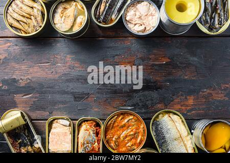 Copyspace-Konzept für Text zwischen zwei Zeilen verschiedener Konserven zubereitetes Gemüse, Fleisch, Fisch und Obst in Dosen. Auf einem hölzernen Hintergrund Draufsicht Stockfoto