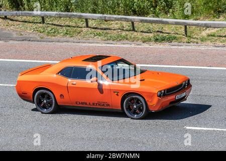 2010 Orange Dodge Challenger; Fahrzeug Verkehr bewegende Fahrzeuge, Autos fahren Fahrzeug auf britischen Straßen, Motoren, Autofahren auf der Autobahn M6 Autobahn Stockfoto