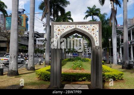 Port Louis, Mauritius - 16. August 2018: Ein kleiner, dekorierter Bogen im Zentrum von Port Louis, Hauptstadt von Mauritius, Ostafrika, mit einem hohen grünen Hügel Stockfoto