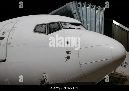 Boeing 737 Nase (Fenster im Cockpit mit Schnee deckt) mit angedockter Fluggastbrücke in der Nacht am Flughafen Stuttgart Stockfoto