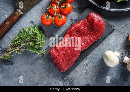 Rohe Tri-Spitze, Boden Sirloin geschnitten Steak auf schwarzem Schiefer roh Bio-Lebensmittel, marmoriertes Rindfleisch über andere alternative Schnitte mit Kräutern Tomaten Pfefferkörner über Stockfoto