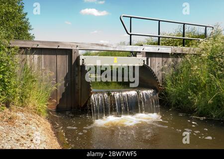 Kleiner Überlaufdamm in einem Fluss zur Kontrolle des Wasserstufe in einem Naturschutzgebiet Stockfoto