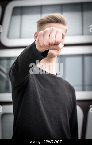 Jugendlicher schlägt mit Faust zu - Gewaltdarstellung Stockfoto