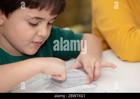 Bild eines Lernspiels, um Fossilien für einen kleinen Archäologen zu finden, mit Kindern Hände graben Stockfoto