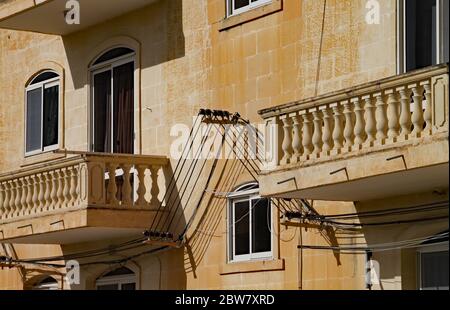 VALLETTA, MALTA - 15. NOVEMBER 2019:Nahaufnahme von zwei Balkonen mit Steinbalustraden auf einem maltesischen Wohnblock mit der außenstromzust Stockfoto