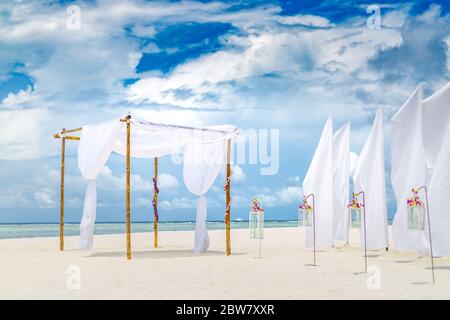 Romantische Trauung am Strand. Exotische Hochzeitszeremonie Ziel, Luxus Dekoration, Kerzen und Blumen unter Hochzeitbogen, Flitterwochen Stockfoto