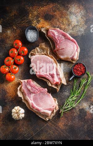 Rohes Schweinefleisch von oben auf Bastelpapier mit Zutaten für Grill rosematy über rustikalen alten Metall Hintergrund Stock Foto. Stockfoto