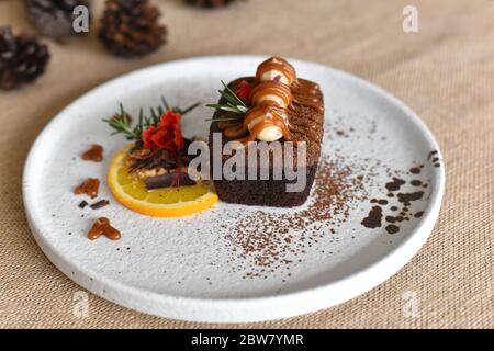 Top-Ansicht Schokolade Brownies mit auf Macadamia und Karamell in der weißen Schüssel auf Sacktuch Hintergrund. Hausgemachte Bäckerei oder Dessert Dekorieren mit Fres Stockfoto