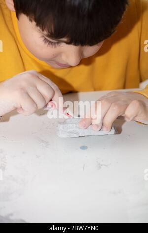 Bild eines Lernspiels, um Fossilien für einen kleinen Archäologen zu finden, mit Kindern Hände graben Stockfoto