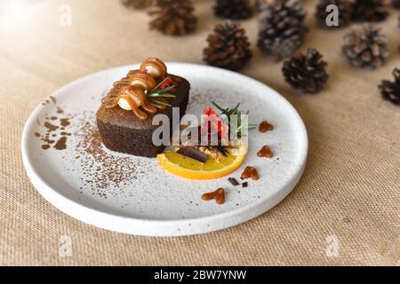 Top-Ansicht Schokolade Brownies mit auf Macadamia und Karamell in der weißen Schüssel auf Sacktuch Hintergrund. Hausgemachte Bäckerei oder Dessert Dekorieren mit Fres Stockfoto