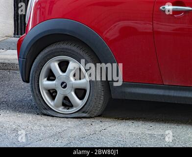 VALLETTA, MALTA - 26. NOVEMBER 2019: Ein roter Mini parkt auf der Straße mit einem Reifenschaden im Hinterreifen Stockfoto