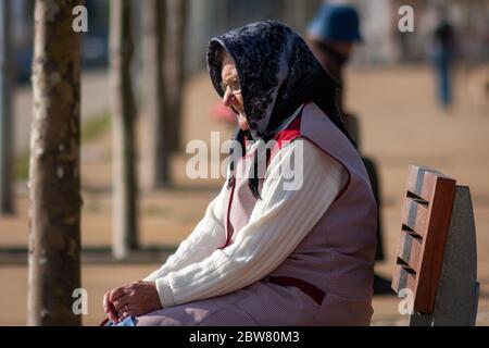 Eine alte Dame sitzt auf der Bank in Foz do Douro, Porto, Portugal Stockfoto