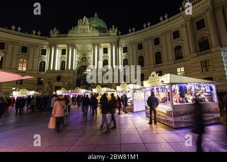 WIEN, ÖSTERREICH - 2. DEZEMBER 2016: Die Außenanlage der Hofburg vom Michaelerplatz in Wien bei Nacht. Weihnachtsmarkt Stände und große amoun Stockfoto