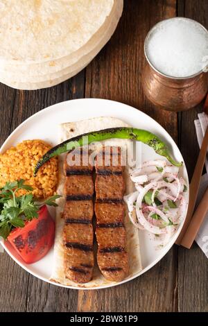 Türkisches Adana Kebap mit Reis-Pilaf und Gemüse auf einem Teller serviert Stockfoto