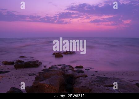 Friedliche Aussicht auf die Steine am Meer am frühen Morgen violetter Sonnenaufgang in Kuwait Beach. Stockfoto