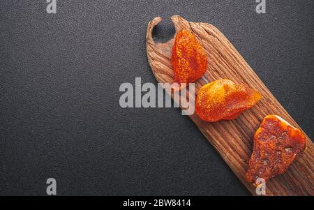 Natürliches Bernstein. Ein Stück gelb transparent Natur Bernstein auf einem Stück strukturiertes Holz, Hintergrund für Design Stockfoto