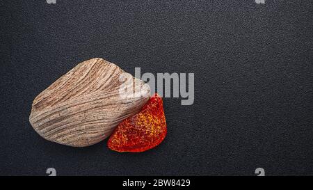 Natürliches Bernstein. Ein Stück gelb transparent Natur Bernstein auf einem Stück strukturiertes Holz, Hintergrund für Design Stockfoto