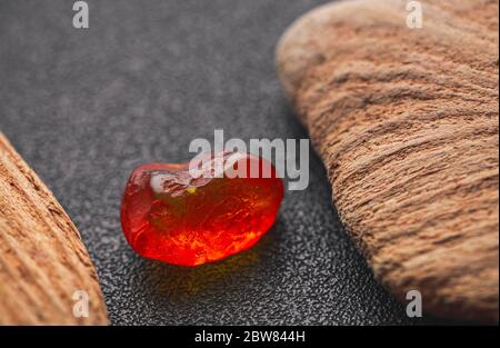 Natürliches Bernstein. Ein Stück gelb transparent Natur Bernstein auf einem Stück strukturiertes Holz, Hintergrund für Design Stockfoto