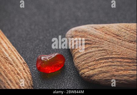 Natürliches Bernstein. Ein Stück gelb transparent Natur Bernstein auf einem Stück strukturiertes Holz, Hintergrund für Design Stockfoto