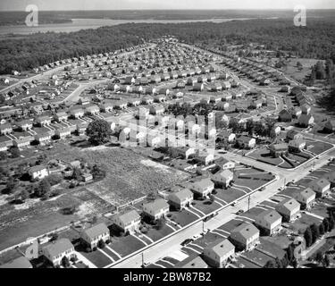 1950ER LUFTAUFNAHME DER WOHNENTWICKLUNG IN ALEXANDRIA VIRGINIA USA ORIGINAL FARM MIT VERBLEIBENDE FLÄCHE MITTE LINKS - A5716 HEL001 HARS LINKS UNIFORMITÄT LUFTAUFNAHME SCHWARZ-WEISS COOKIE CUTTER ALTMODISCHE BEVÖLKERUNG NACH DEM KRIEG Stockfoto