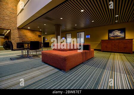 Innenansicht der Hotellobby und des Konferenzbereichs mit Einrichtung in warmen Farbtönen und Beleuchtung in kühlen Farbtönen Stockfoto