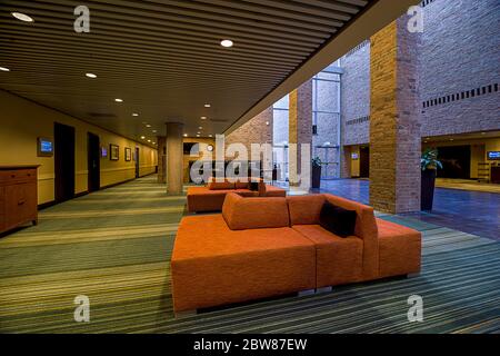 Innenansicht der Hotellobby und des Konferenzbereichs mit Einrichtung in warmen Farbtönen und Beleuchtung in kühlen Farbtönen Stockfoto