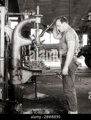 1950S 1960S MANN MASCHINIST STEHEND ARBEITEN EINE BOHRPRESSE BOHREN EIN LOCH IN EINEM METALLKRAGEN SCHWERE MASCHINENWERKSTATT BETREIBER - I3271 HAR001 HARS GESCHICKLICHKEIT BERUF FÄHIGKEITEN OPERATING OPERATOR BOHREN MASCHINEN HANDBUCH KARRIERE ARBEIT A IN BERUFEN VERBINDUNG HANDARBEIT MITARBEITER HANDEL BLAUE JEANS JUNGER ERWACHSENER MANN SCHWARZ UND WEISS KAUKASISCHE ETHNIZITÄT HAR001 MASCHINIST ALTMODISCH Stockfoto