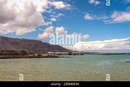 Weißer Sand und schwarze Lavafelder am Strand von Caleton Blanco, Lanzarote, Kanarische Inseln, Spanien. Vulkanstrand von Lanzarote Island, Kanaren, Spanien Stockfoto