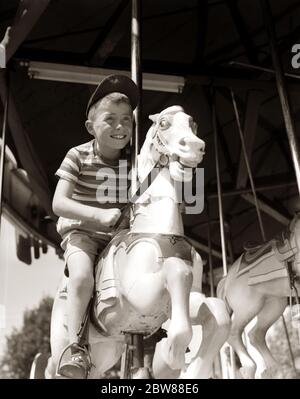 1940S 1950ER JAHRE EIFRIG LÄCHELNDEN JUNGEN TRÄGT BALL CAP UND GESTREIFTEN T-SHIRT REITEN AUF GESCHNITZTEN HOLZ KARUSSELL PFERD - J11012 HEL001 HARS 1 SHORTS JUGENDLICH AUFGEREGT BALANCE FREUDE LIFESTYLE GESCHWINDIGKEIT GESTREIFTEN VERTIKALEN GESUNDHEIT STREIFEN KOPIE RAUM MENSCHEN KINDER VOLLE LÄNGE JUGENDLICHE MÄNNER SONNENLICHT SONNIG AMERICANA B & W PRETEEN JUNGE SINGULAR TRÄUME SONNENSCHEIN GLÜCK ARCHIV UND AUFREGUNG ERHOLUNG KARUSSELL RICHTUNG MERRY-GO-ROUND IN AUF GESCHNITZTEN PRETEEN REIN TAGSÜBER PRE-TEENAGER STILVOLLE T-SHIRT KARUSSELL PFERD TAGESLICHT EIFRIG JUGENDLICHE FREIZEITPARK SCHWARZ UND WEISS KAUKASISCHEN ETHNIZITÄT SOMMERSPROSSEN Stockfoto