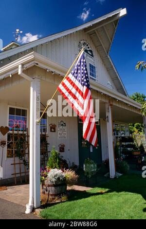 1990ER JAHRE AMERIKANISCHE FLAGGE VOR ANONYMEN KLEINBETRIEB LEBENSMITTEL UND ALLGEMEINE CONVENIENCE-STORE HÄNGEN - KB31417 LGA001 HARS EIGENSCHAFT KUNDENSERVICE UND AUSSEN NIEDRIGEN WINKEL STOLZ IN DER SCHNELLEN IMMOBILIEN KONZEPTIONELLE STRUKTUREN STERNE UND STREIFEN STILVOLLE UNTERSTÜTZUNG GEBÄUDE ANONYME SYMBOLISCHE ZUSAMMENARBEIT ROT WEISS UND BLAU CONVENIENCE ALTMODISCH Stockfoto