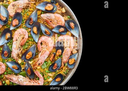 Transparenz geschnitten, schwarzer Hintergrund, Paella typisch spanischen Küche, mit Meeresfrüchten Gemüsefleisch und Reis Stockfoto