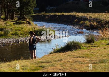 Llanos del Hospital, Huesca/Spanien; 21. August 2017. Eine Frau entspannt sich am Fluss. Ort namens Llanos del Hospital gehört zur Gemeinde Bena Stockfoto