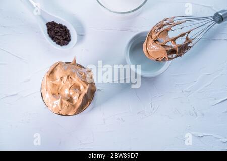 Koreanischer Dalgona Kaffee im Glas mit Schlagkaffee und Schokolade auf weißem Hintergrund. Draufsicht. Flaches Lay. Stockfoto