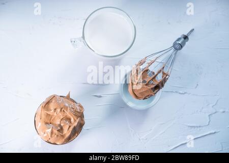 Dalgona Kaffee im Glas, Milch in einer Tasse und mit Schlagkaffee verrühren. Koreanischer trendy Kaffee. Draufsicht. Flaches Lay. Stockfoto