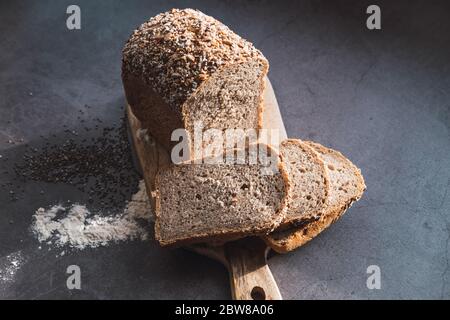 Laib und Scheiben von hausgemachtem Buchweizenbrot auf Holztisch. Stockfoto