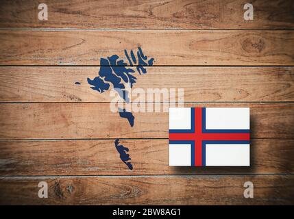 Karte und Flagge der Färöer Inseln auf Holzhintergrund, 3D-Illustration Stockfoto