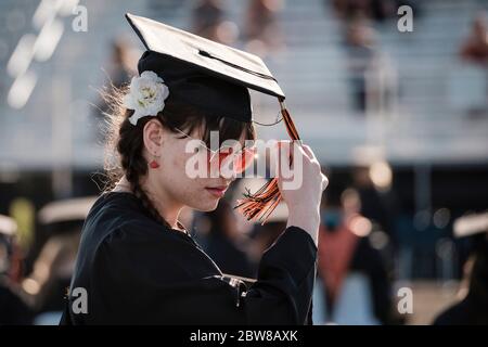 Kalispell, Montana, USA. Mai 2020. Klasse von 2020 - EIN Flathead High School Absolvent wirft ihre Quaste während ihrer sozialen Distanzierung Zeremonie, die Schüler auf zwei Familienmitglieder begrenzt jeder an der Veranstaltung Freitag Abend im Legends Field in Kalispell, Montana. Die Schüler haben ihr letztes Schuljahr praktisch wegen der COVID-19 Pandemie beendet. Quelle: Kent Meireis/ZUMA Wire/Alamy Live News Stockfoto