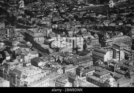 Rumänien , Bukarest . Eine Luftaufnahme zeigt den Abschnitt der Stadt zwischen dem zentralen Postamt (links) und dem Fluss Dambovitsa. Das große Gebäude mit der Kuppel, gegenüber dem Postamt, ist die Nationale Sparkasse. 21 Februar 1929 Stockfoto