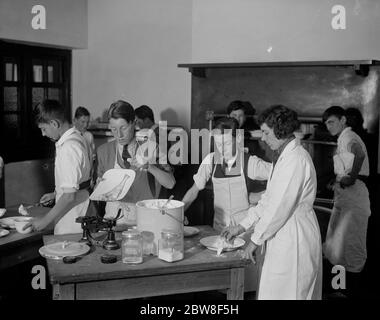 Wo die Jungen kochen lernen und die Mädchen Tischlerei machen. Einige der Jungs in der Kochklasse, an der Thames Valley County School twickenham. November 1931 Stockfoto