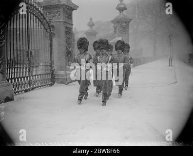 Echtes winterliches Wetter in London . Eine Szene außerhalb des Buckingham Palace während des Wachwechsels, in der Wachmänner im pelzigen Schnee marschieren. 10 Februar 1932 Stockfoto