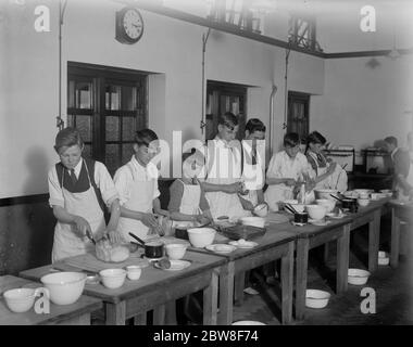 Wo die Jungen kochen lernen und die Mädchen Tischlerei machen. Einige der Jungs in der Kochklasse, an der Thames Valley County School twickenham. November 1931 Stockfoto