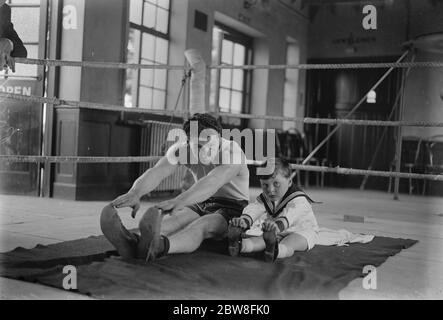 Len Harvey 's Sohn besucht sein Vater 's Trainingslager während seiner Ausbildung für die Welt 's Titelspiel. Len Harvey und Terry sein Sohn berühren Zehen auf der Matte zusammen, bei Whetstone. 18 Juni 1932 Stockfoto