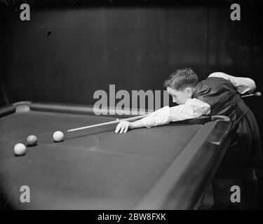 Boy ' s Billard Meisterschaft . Spielen Sie in den Jungen Billard-Meisterschaften begann in Burwat Hall, Soho Square. William Swinhoe, von Shire Moor, Northumberland, im Alter von 10, die einen Abschied in der ersten Runde, am Übungstisch erhalten. 28 Dezember 1931 Stockfoto