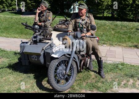 Kiew, Ukraine - 27. Mai 2018: Männer tragen deutsche Soldaten Kleidung auf Motorrad beim historischen Wiederaufbau Festival Stockfoto