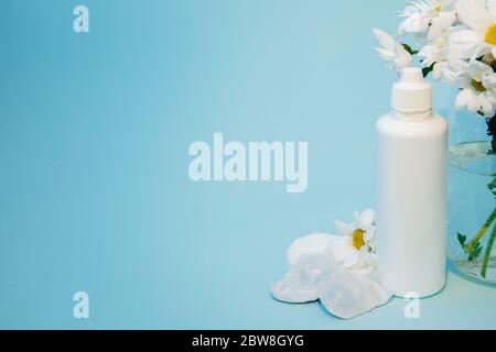 Das Kontaktlinsenwechselkit ist neben einer Reihe von Gänseblümchen. Stockfoto