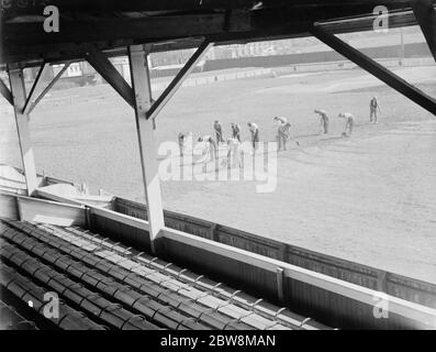 Northfleet United - die Weitergabe des Platzes auf Northfleet United's Stonebridge Road Ground. - 1935 Szene aus den Zuschauertribünen, Arbeiter auf dem Platz auf dem Fußballplatz Northfleet. 1935 Stockfoto