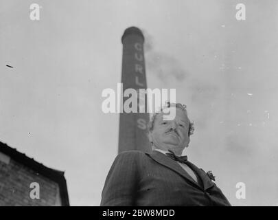 Mr W Arrowsmith, Gründer von WJ Curley und Söhne (sein Spitzname war curley wegen seiner Haare) und der Kamin in seiner Fabrik in Stratford, East London. Oktober 1937 Stockfoto