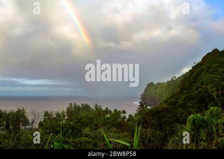 Nach dem Regen erscheint ein Regenbogen über der Hamakua Küste, am Laupahoehoe Point, auf der Big Island von Hawaii. Die Duschen fallen immer noch unter die Kl Stockfoto