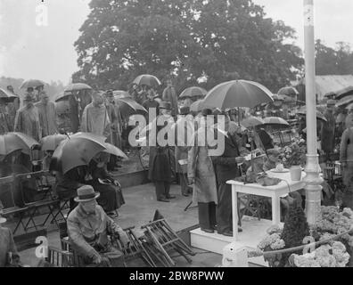 Bexleyheath Schwimmbäder öffnen. Die Menge decken sich unter ihren Sonnenschirmen. 1936. Stockfoto