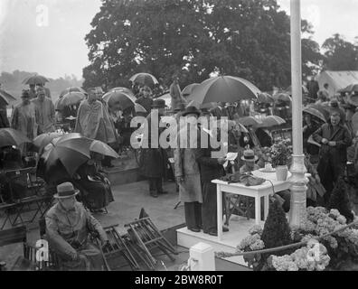 Bexleyheath Schwimmbäder öffnen. Die Menge decken sich unter ihren Sonnenschirmen. 1936. Stockfoto